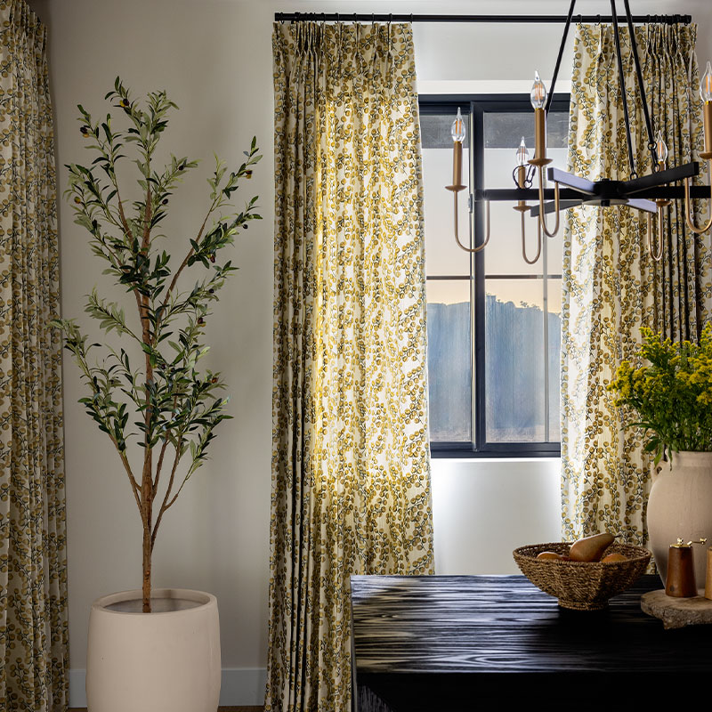 A dark dining room featuring custom EZ Panels from Carole Fabrics on the window in a foliage inspired embroidered fabric.