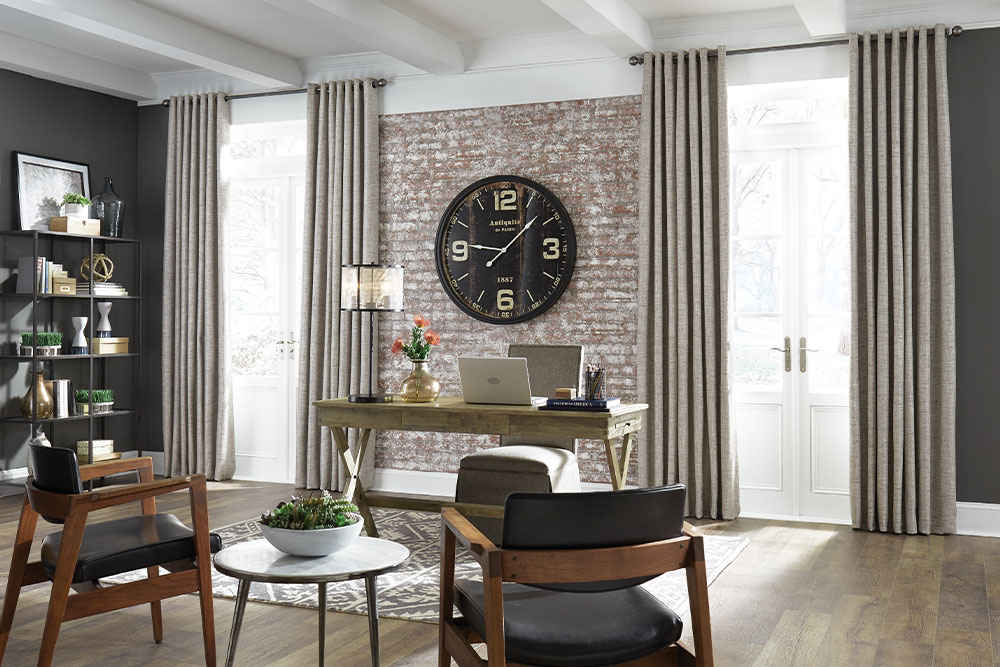 Grommet Heading Drapery over French doors in an office with a brack wall.