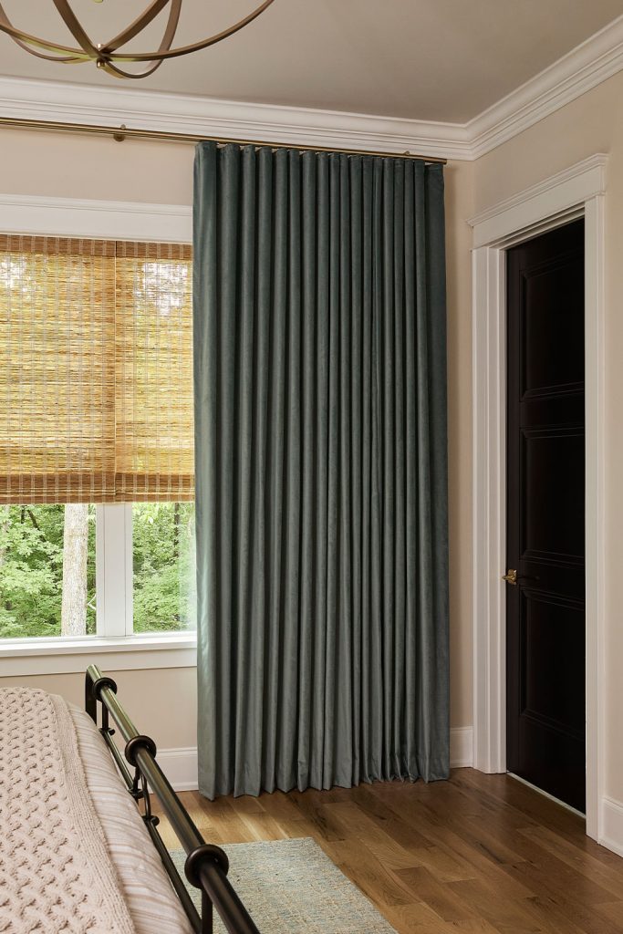 Dark green Ripplefold Drapery over natural shades.