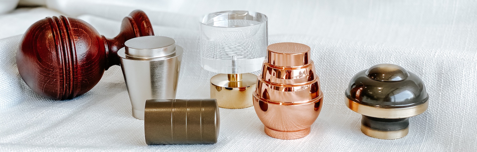 Six styles of Drapery Hardware finials from Carole Fabrics on a white fabric background.