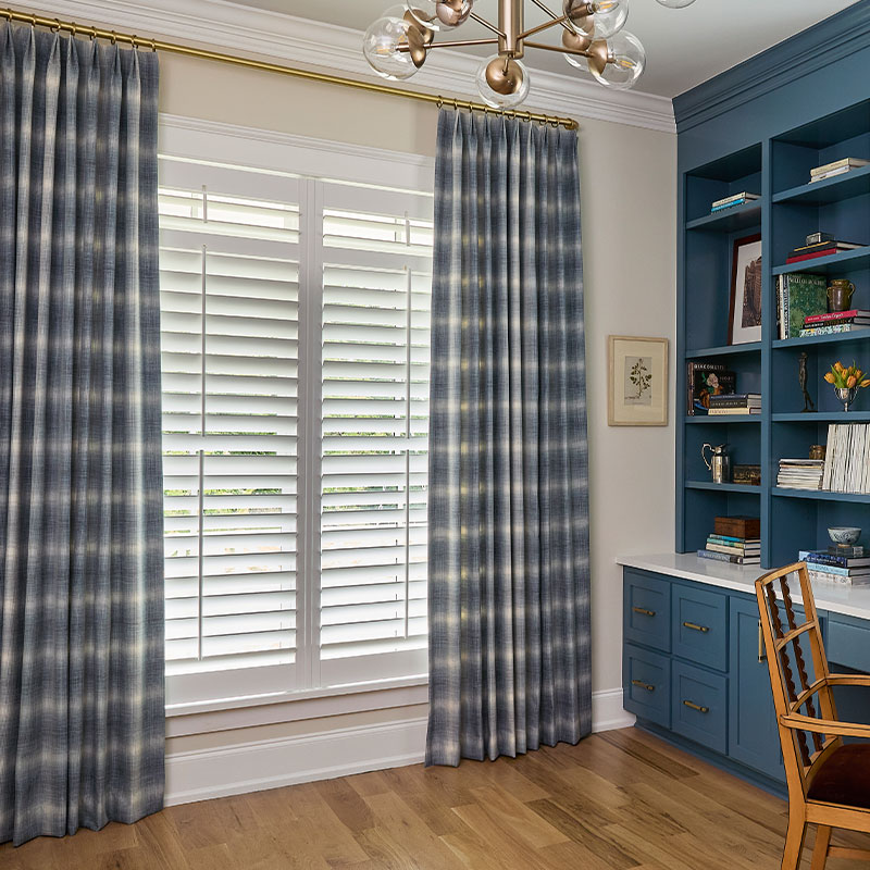 Home office with medium blue bookshelves featuring a window with blue and off-white large scale plaid EZ panels.